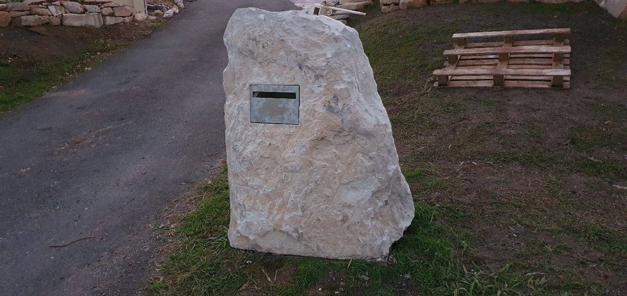 Rustic sandstone letterbox side view showing stone character